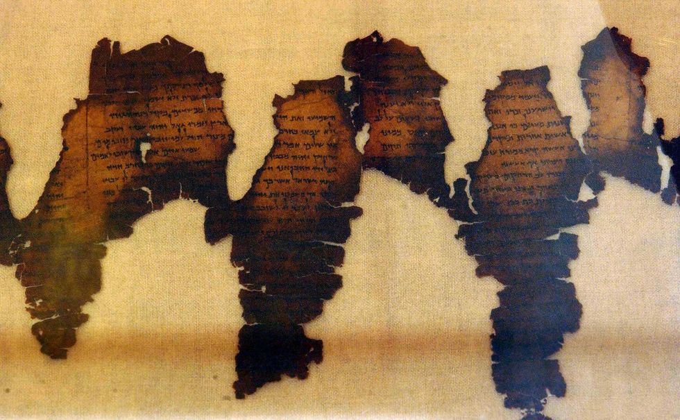 fragments of the dead sea scrolls, considered one of the greatest archeological discoveries of the 20th century, are displayed 18 june 2003 at  montreal's pointe a callieres archeological museum,  the first time they have been out of israel stumbled upon in 1947 in a cave near khirbat qumran on the left bank of the dead sea by a bedouin searching for an errant goat, the scrolls are considered a direct link to the origins of the bible   "the dead sea scrolls are the greatest patrimony of israel, maybe of the jews they are our mona lisa, but they are more than that," said james snyder, curator of the jerusalem museum that loaned the pieces to the canadians  afp photonormand blouin  photo credit should read normand blouinafp via getty images