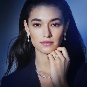 close up of a woman wearing a diamond ring, diamond necklace and diamond earrings