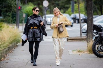 a woman wears a pair of black leggings and a cape to illustrate a roundup of the best leggings on amazon 2021