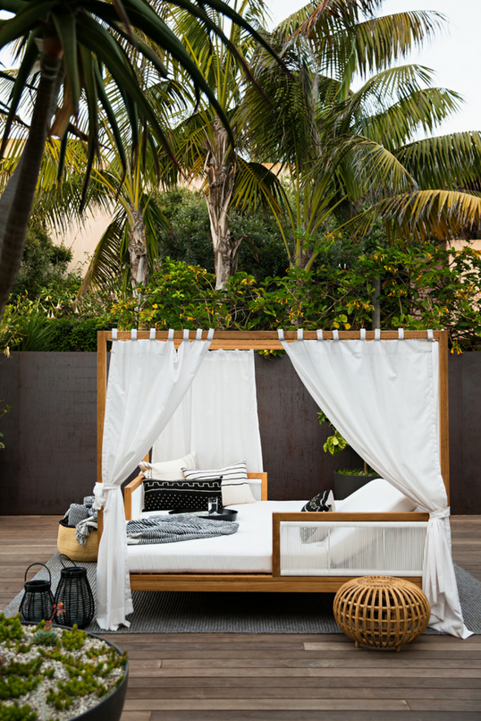 deck with daybed and palm trees