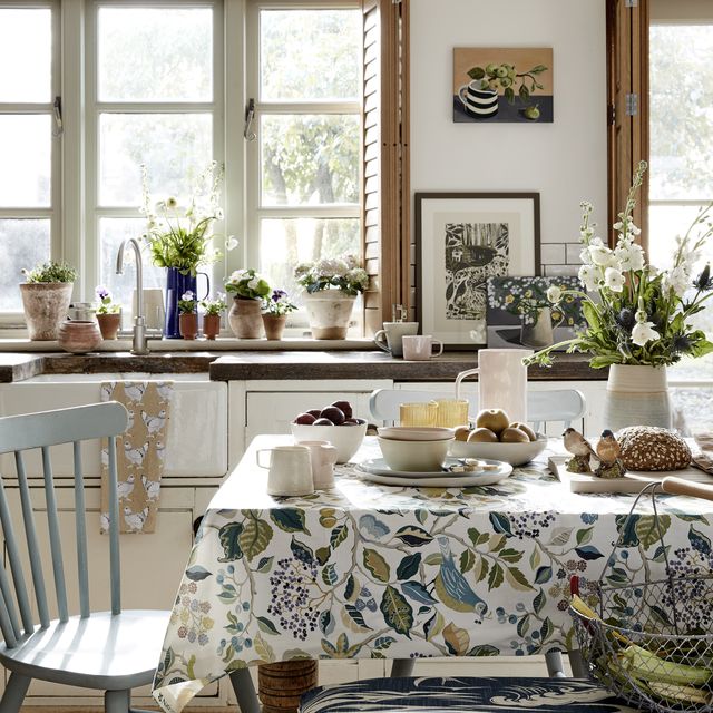 a country kitchen featuring a dining room table filled with tasty treats and fresh flowers