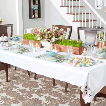 mesa de pascua con centros de flores y huevos pintados