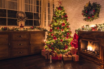 decorated christmas tree near fireplace at home