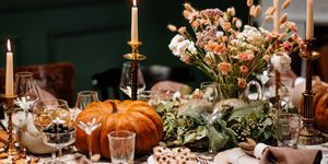 decoration and serving of the festive table with autumn decor, candles and flowers and pumpkins and dishes