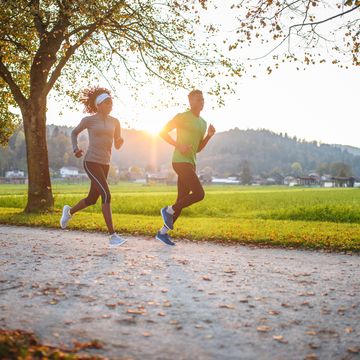 dedicated athletes running in public park at sunset