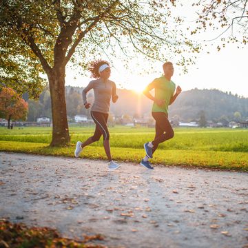 dedicated athletes running in public park at sunset