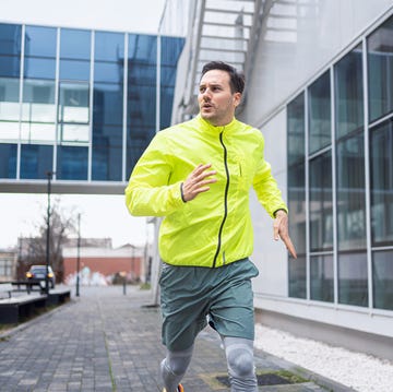 un joven atleta caucásico corriendo en el centro de la ciudad