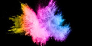 defocused image of multi colored powder paints against black background