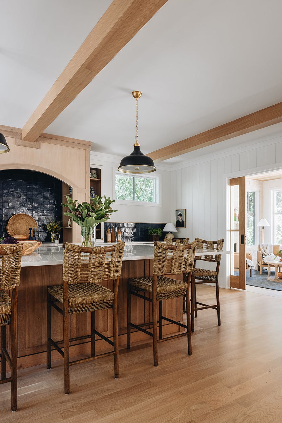 Modern kitchen with tall bar stools and a black pendant light