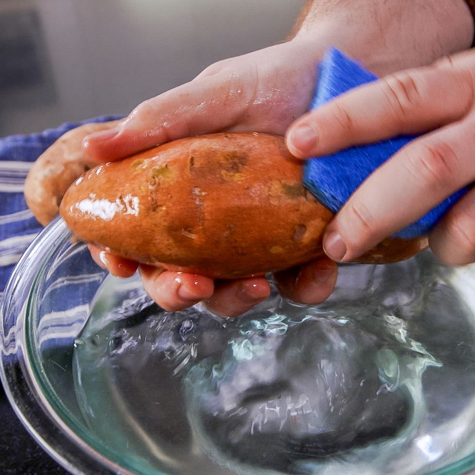 scrubbing a sweet potato