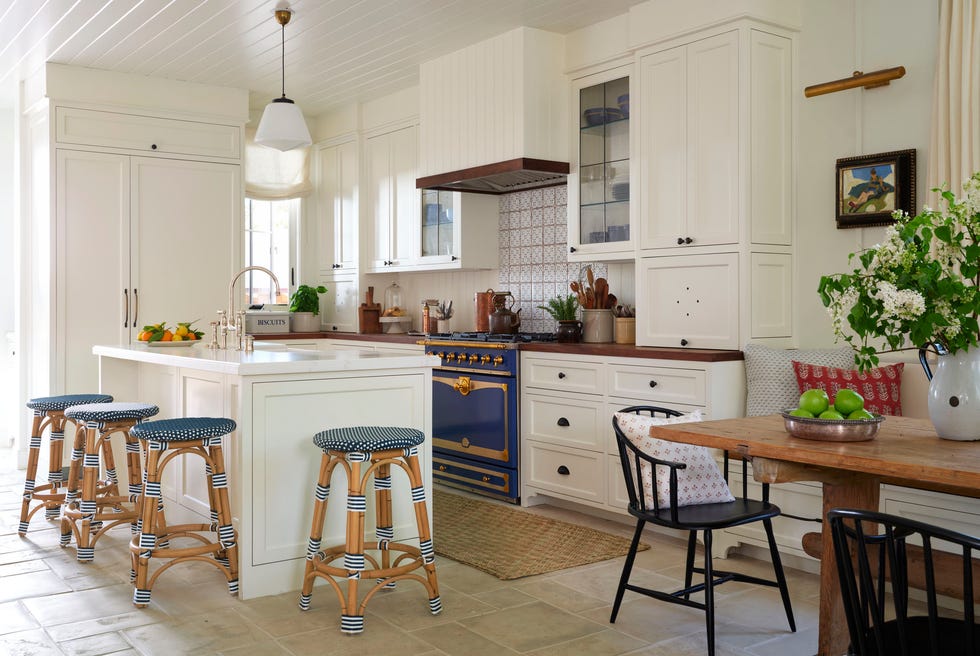 a white kitchen with blue range and blue and white woven bar stools a white kitchen with blue range and blue and white woven bar stools