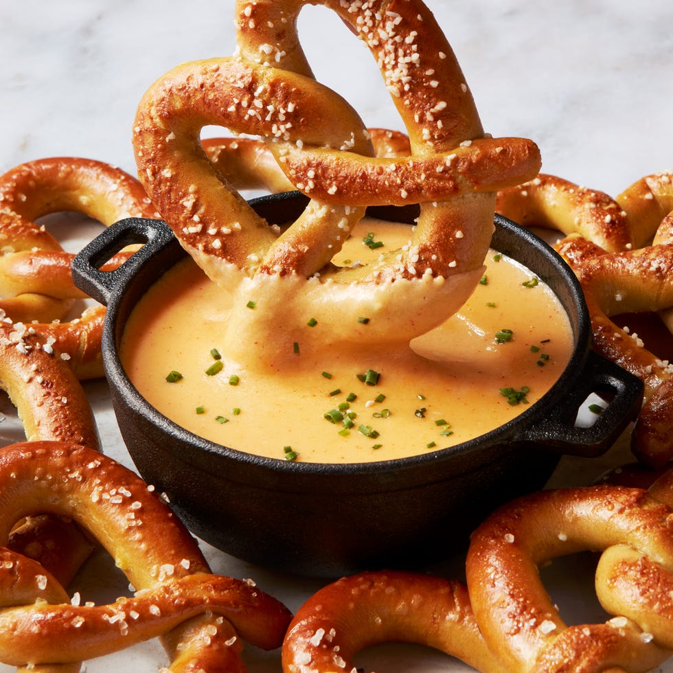 beer cheese in a black pot topped with chives and surrounded by soft pretzels