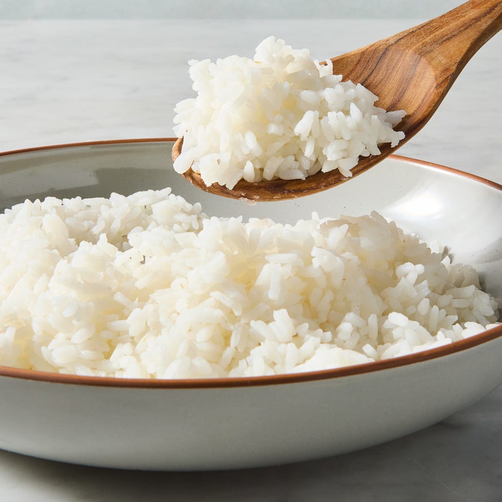 wooden spoon lifting sushi rice from a bowl of a sushi rice