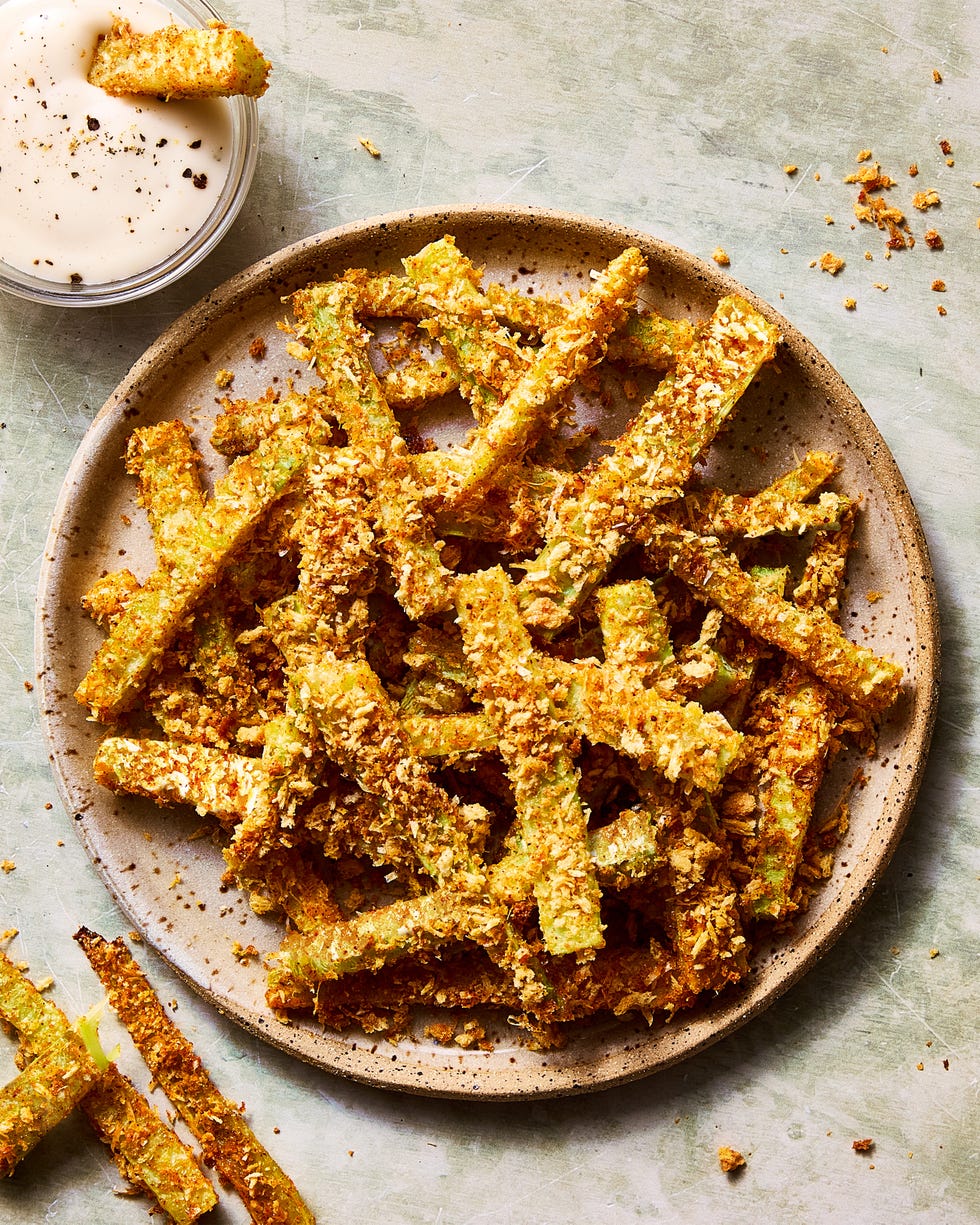 crispy parmesan broccoli stem fries on a plate beside a bowl of ranch dipping sauce
