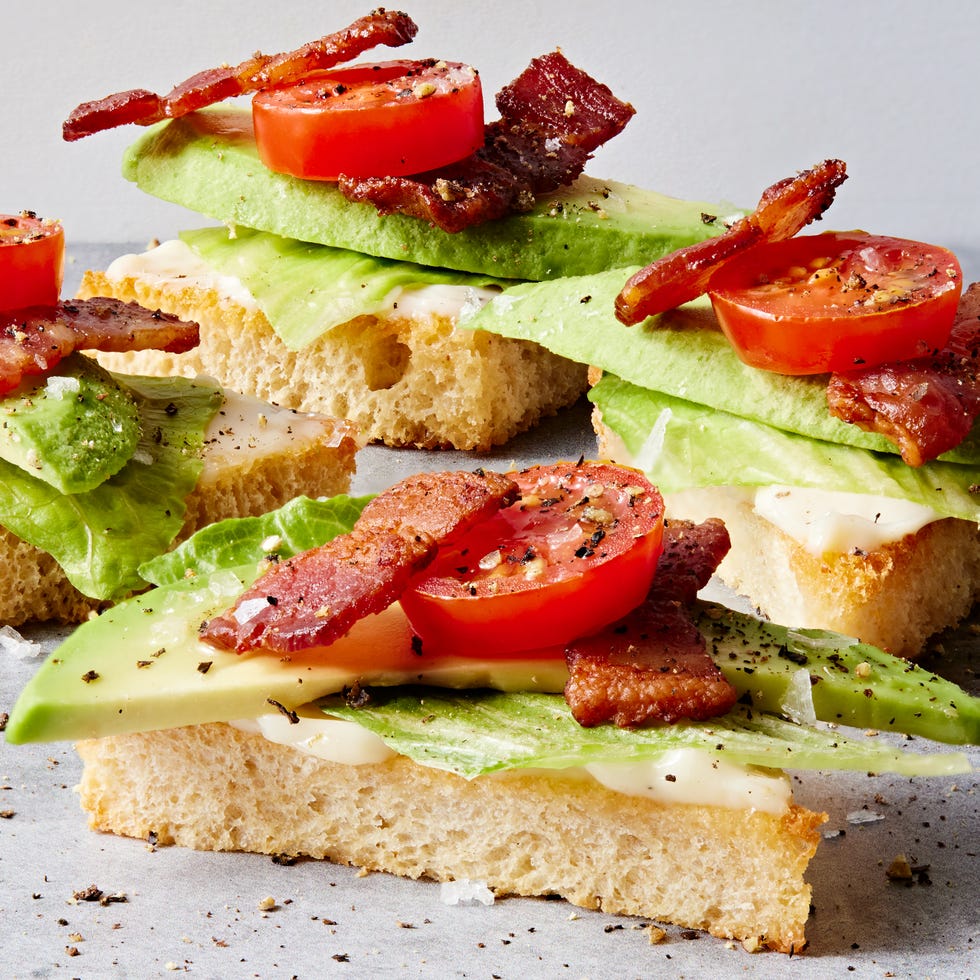 white toast points topped with lettuce, avocado, bacon, and tomato