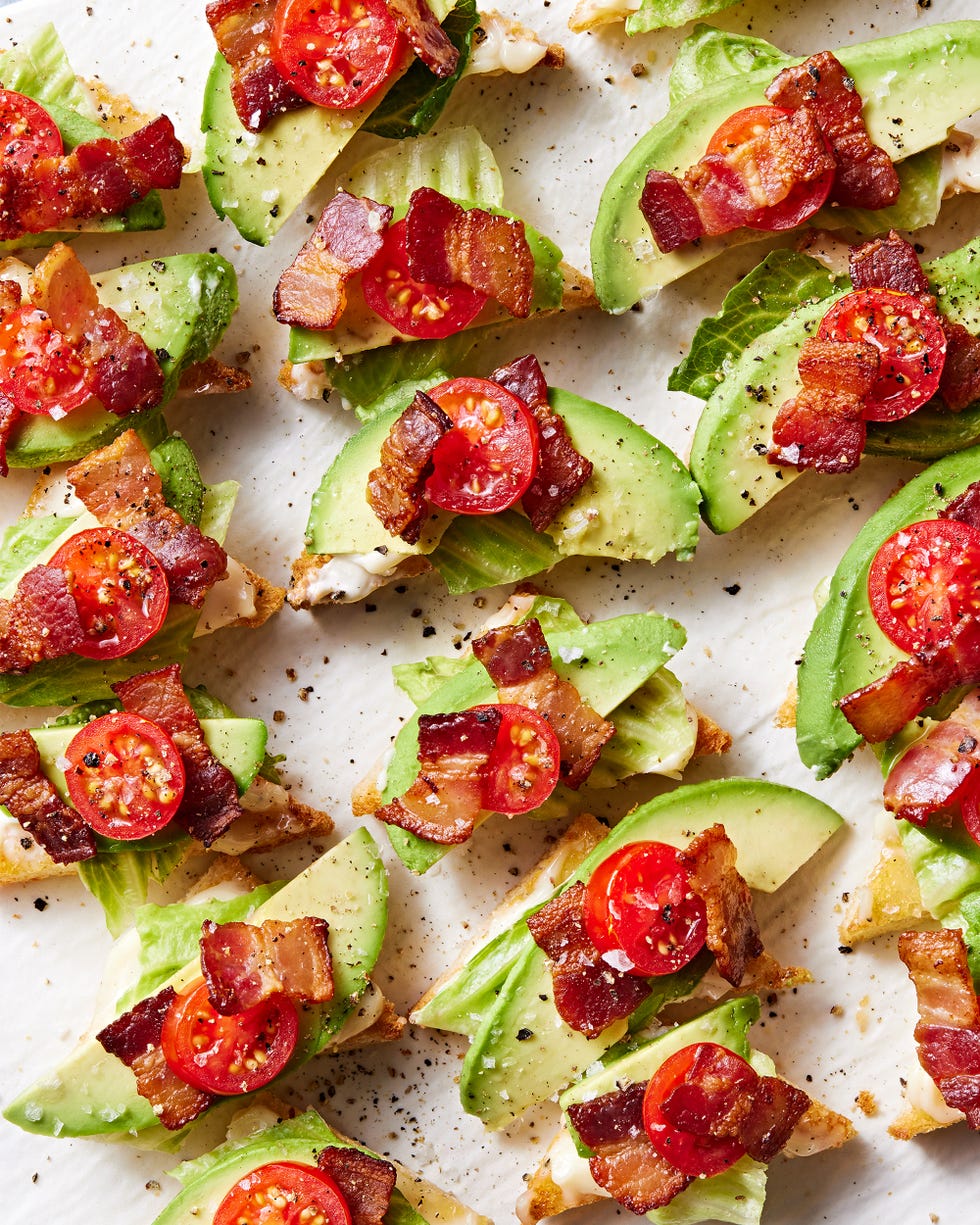 white toast points topped with lettuce, avocado, lettuce, and tomato