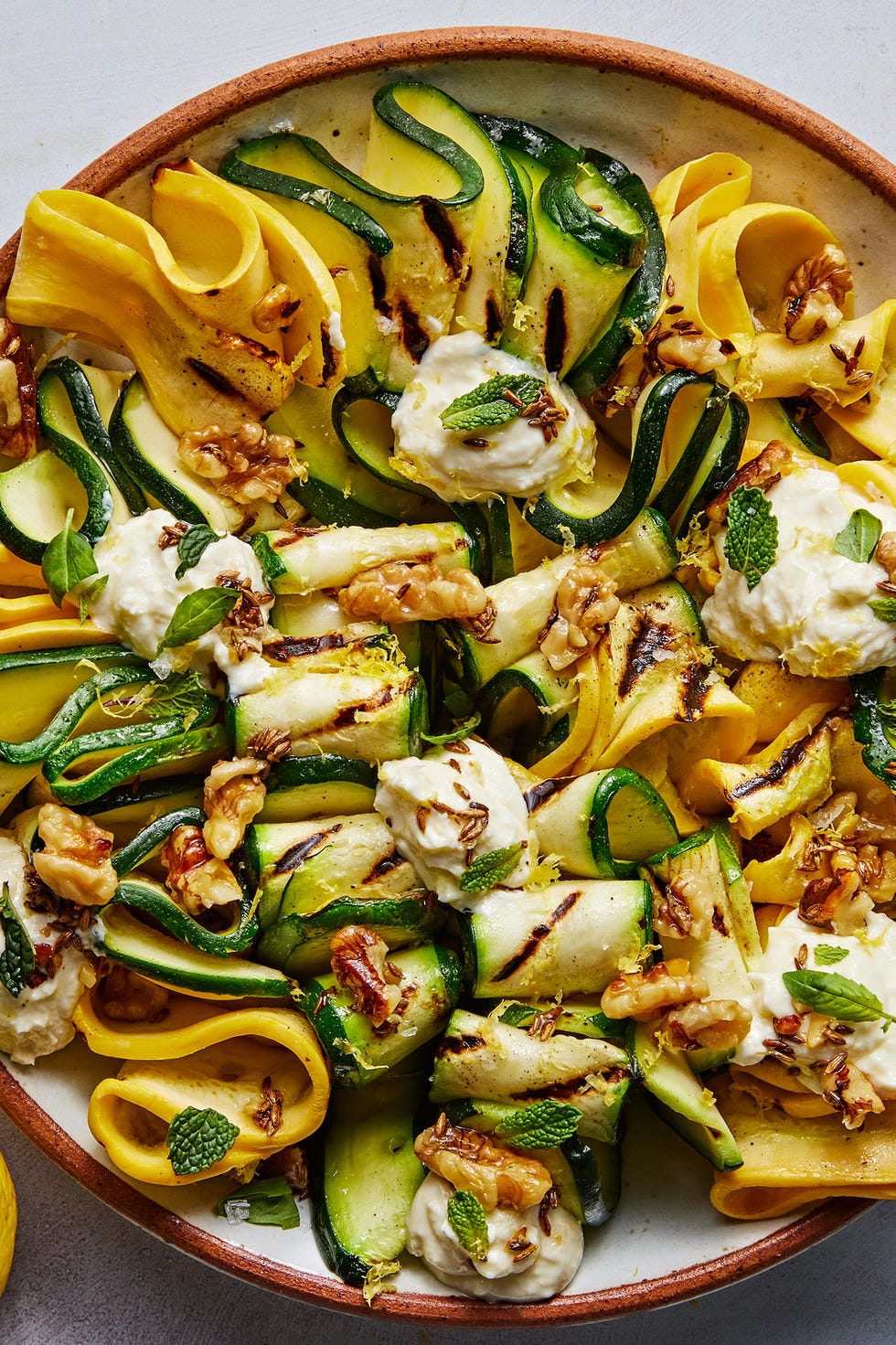 skewered and grilled zucchini planks topped with herby whipped ricotta and crunchy toasted walnuts