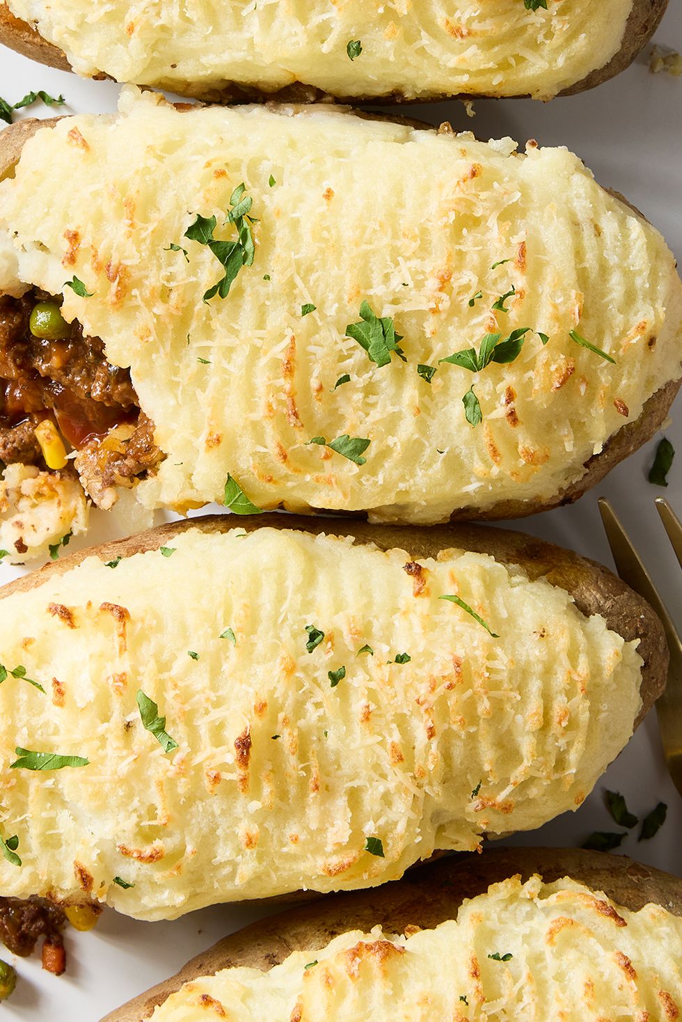 a saucy red wine spiked ground beef and vegetable mixture gets loaded into hollowed out russet potatoes, topped with parmesan mashed potatoes, and baked until golden brown