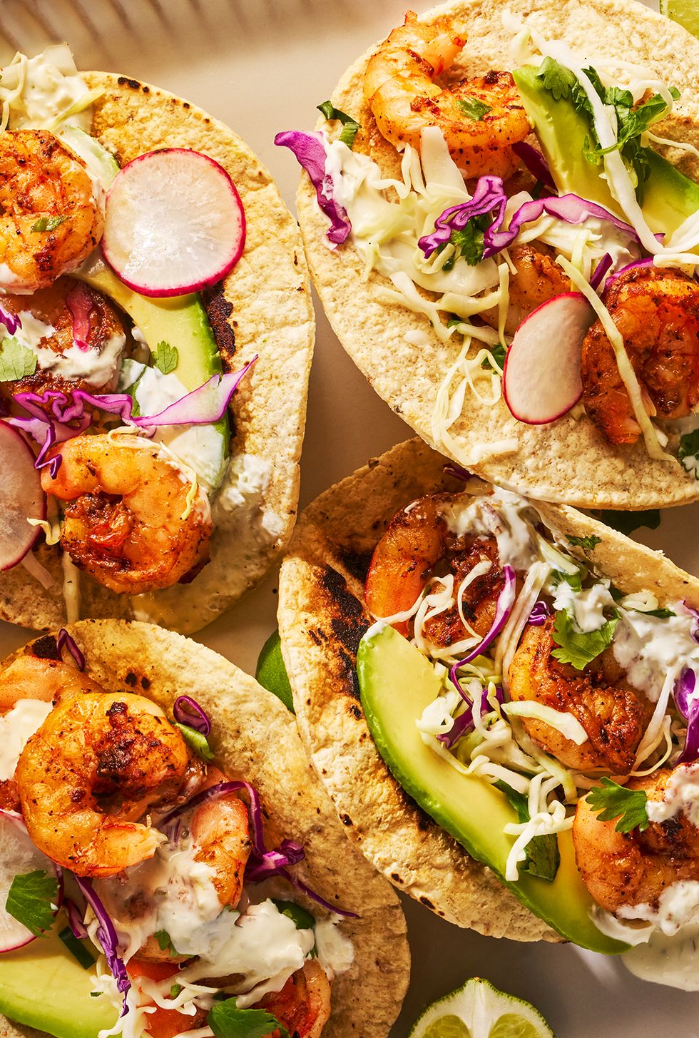 seasoned and seared shrimp topped with crisp cabbage slaw and creamy pickled jalapeno crema on a toasted corn tortilla