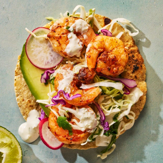 seasoned and seared shrimp topped with crisp cabbage slaw and creamy pickled jalapeno crema on a toasted corn tortilla