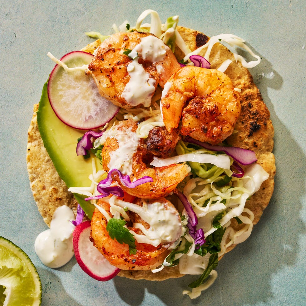 seasoned and seared shrimp topped with crisp cabbage slaw and creamy pickled jalapeno crema on a toasted corn tortilla