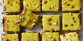 melted dark chocolate and cocoa powder brownies blended baked with chopped roasted pistachios and topped with homemade pistachio ganache