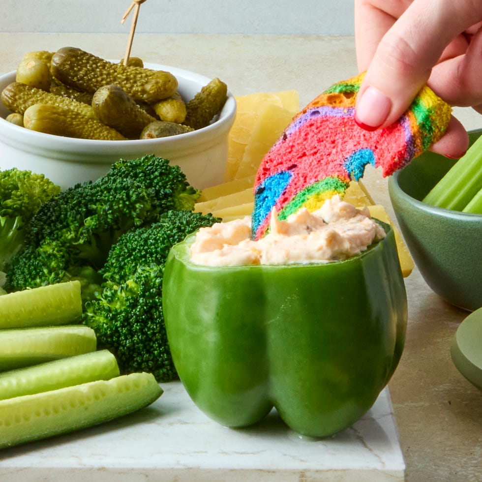 decked out board is loaded with corned beef, irish cheddar, kettle cooked potato chips, hard pretzels, rainbow bagel chips, and fresh veggies then surrounded by baby gherkin pickles, grainy mustard, sauerkraut, and dip stuffed bell peppers