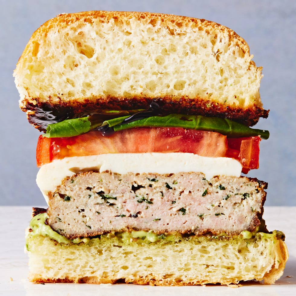half of a caprese turkey burger topped with mozzarella, tomato, basil, and balsamic drizzle