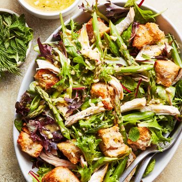 spring chicken panzanella salad topped with asparagus, peas, and shredded chicken