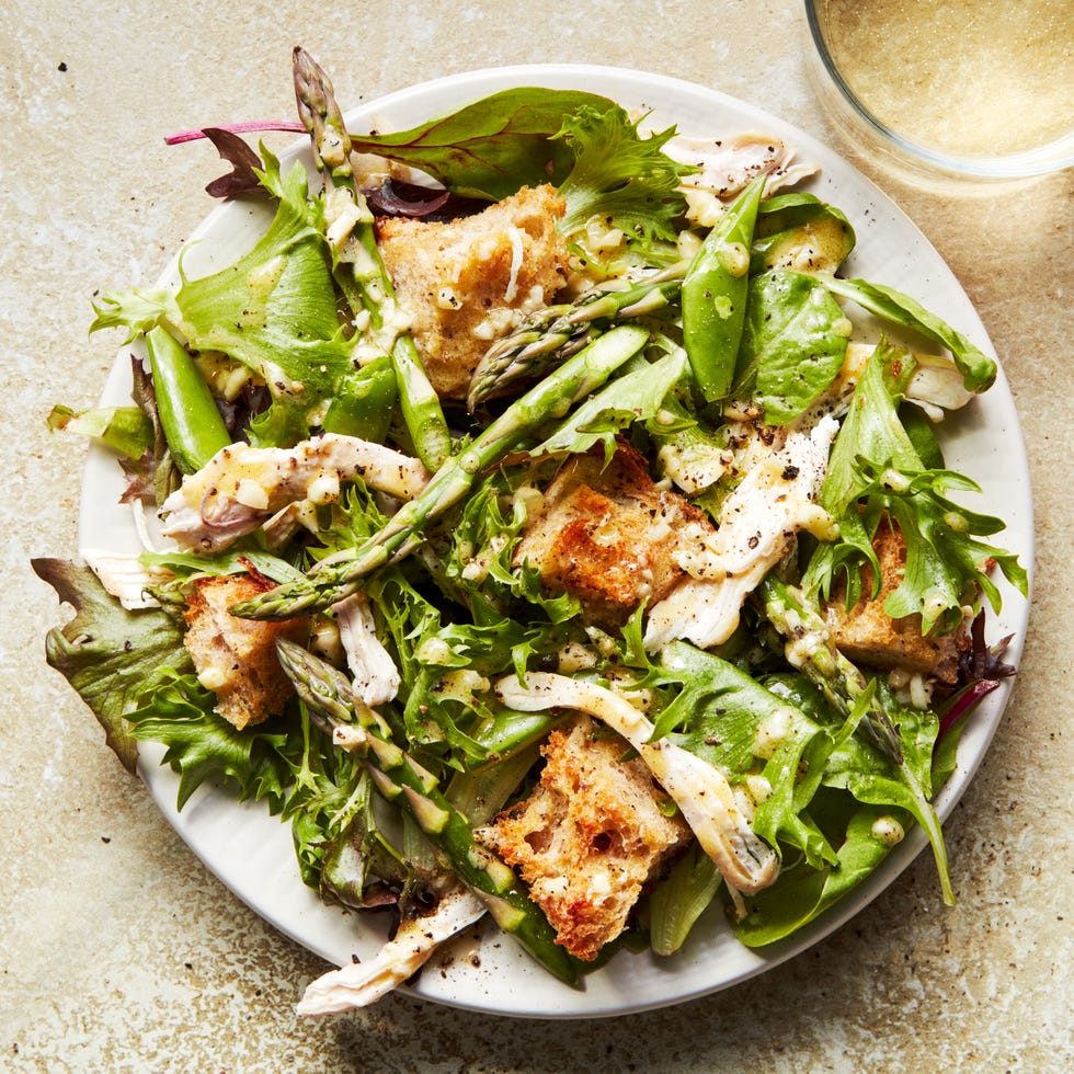 spring chicken panzanella salad topped with asparagus, peas, and shredded chicken