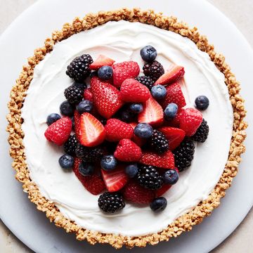 no bake fruit and granola breakfast tart topped with raspberries, blueberries, blackberries, and strawberries on a platter