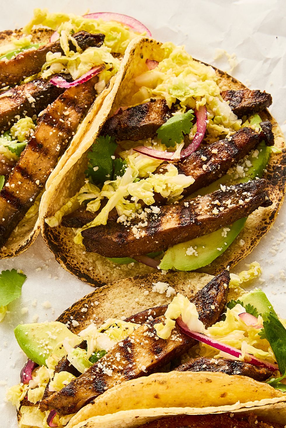 grilled portobello tacos topped with cabbage slaw, avocado, and queso fresco