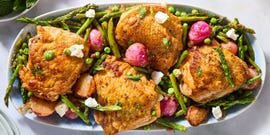 crispy chicken thighs with roasted radishes, asparagus, and peas on a white platter