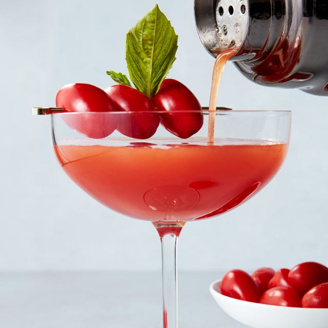 martini glasses with gin, tomato infused vermouth, and a basil leaf