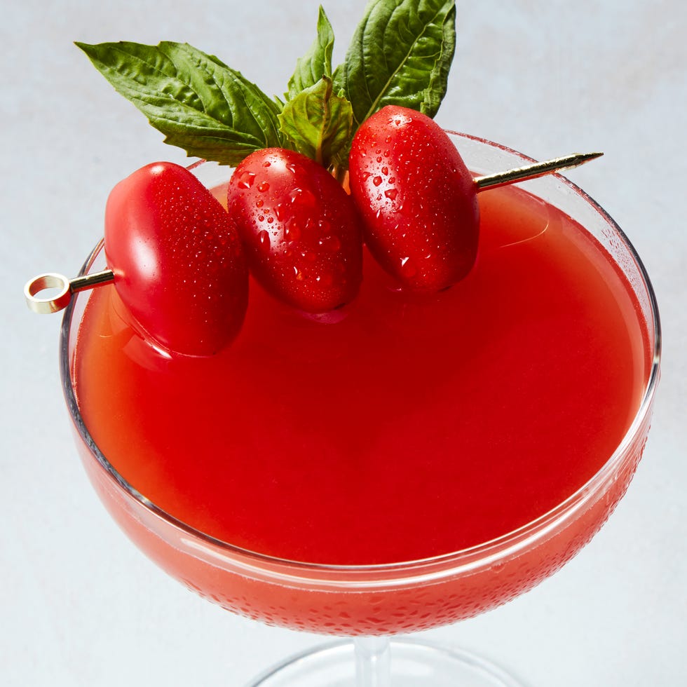 martini glasses with gin, tomato infused vermouth, and a basil leaf