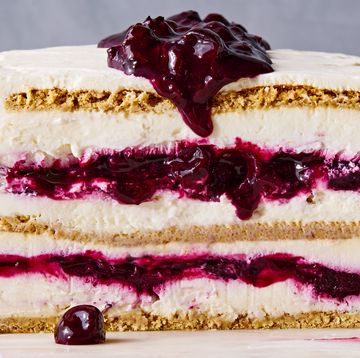 blueberry cheesecake icebox cake with layers of graham crackers, whipped cheesecake, and blueberry jam on a marble slab