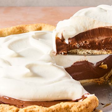 a slice of chocolate cream pie lifting out of the larger pie