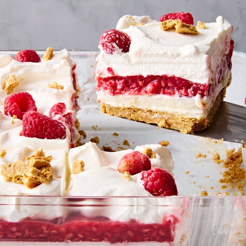 no bake raspberry cheesecake lasagna slice lifting out of a glass baking dish