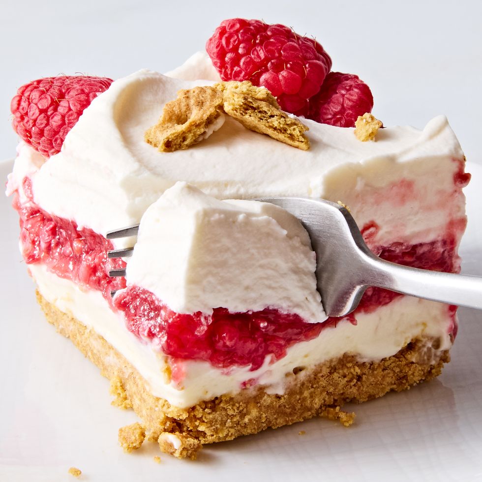a fork slicing into a slice of raspberry cheesecake lasagna