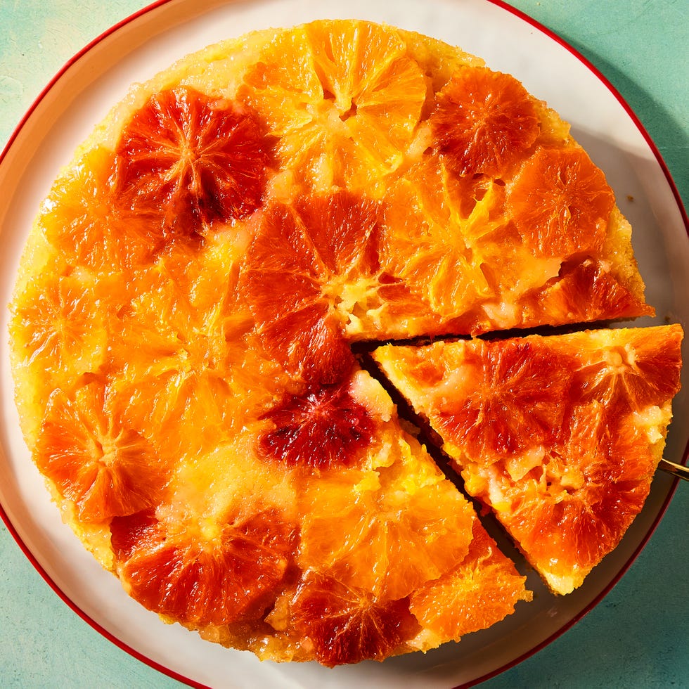 a slice of shortcut citrus upside down cake coming out of the larger cake