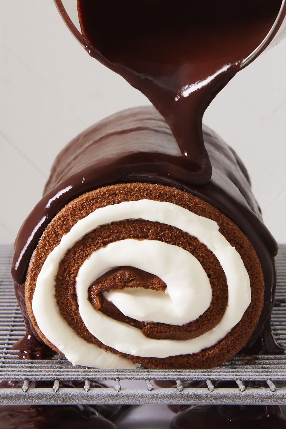 swiss roll cake with chocolate ganache poured over
