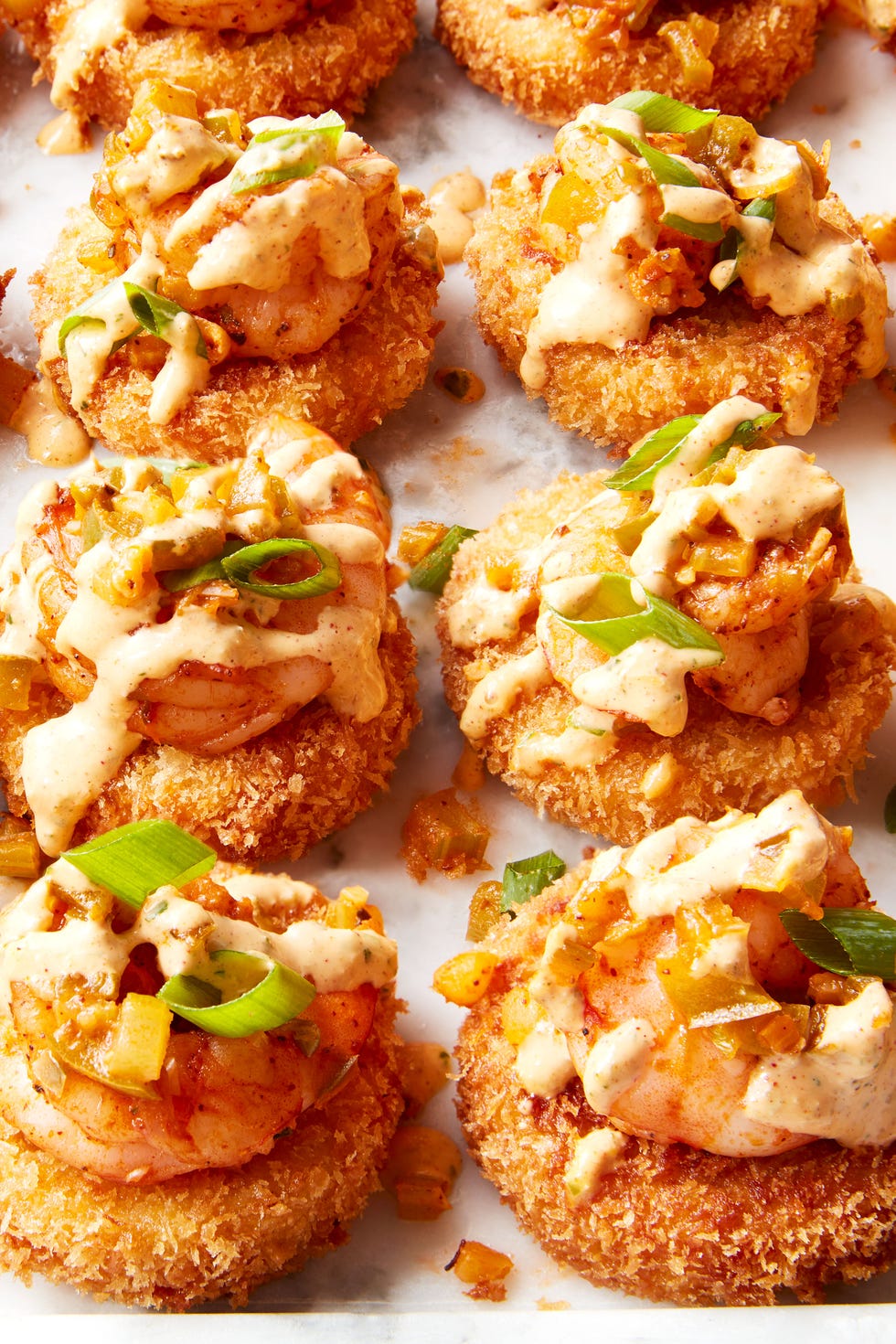 Cheese Shrimp & Grit Bites Smoked Gouda grits breaded and fried until crispy, topped with Cajun shrimp and creamy remoulade sauce.