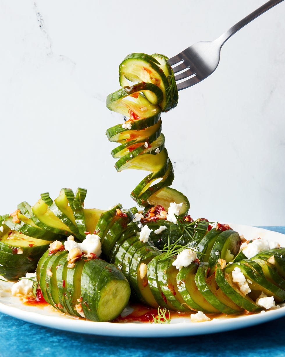 fork holding a piece of viral spiral cucumber salad dressed in harissa with feta