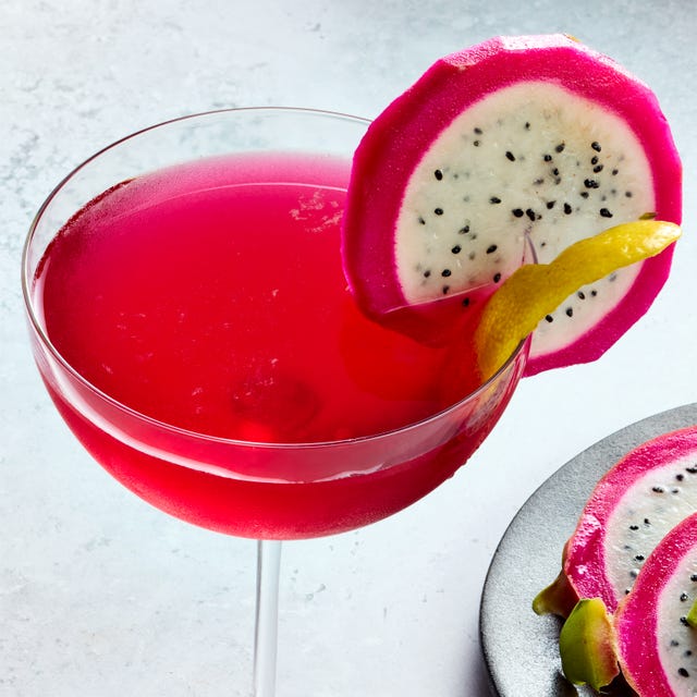 Dragon Fruit Drop Martini two coupe glasses filled with a bright pink vodka based cocktail and garnished with a slice of dragon fruit and a lemon twist