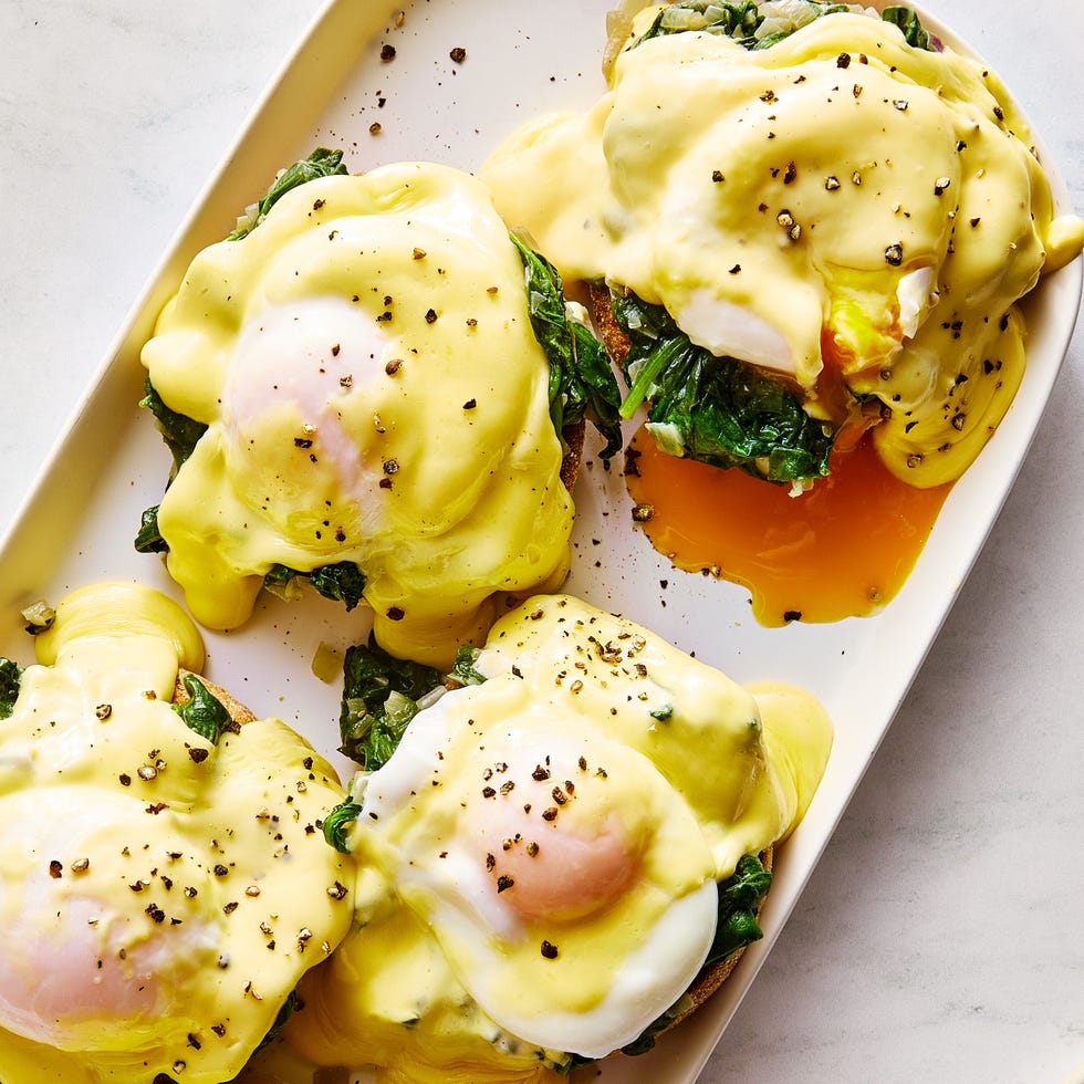 eggs florentine on a platter topped with hollandaise and black pepper