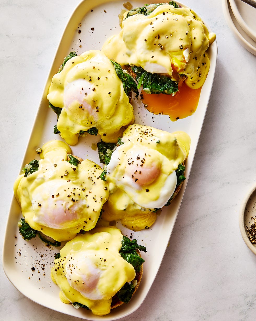 eggs florentine on a platter topped with hollandaise and black pepper
