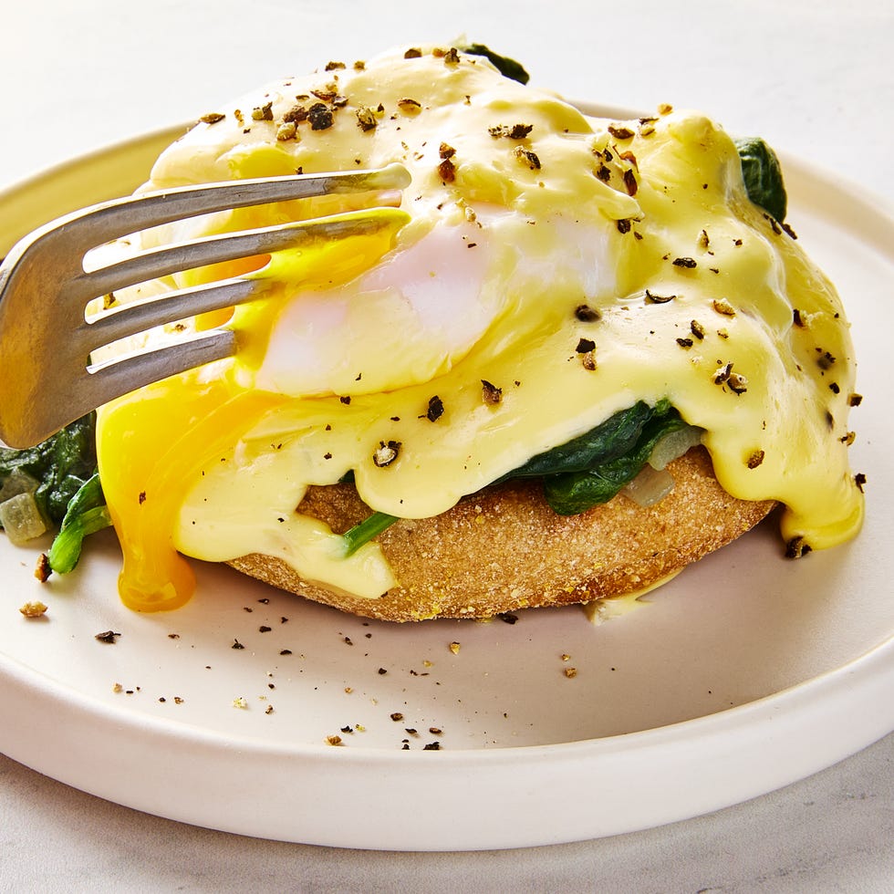 eggs florentine on a plate topped with hollandaise and black pepper