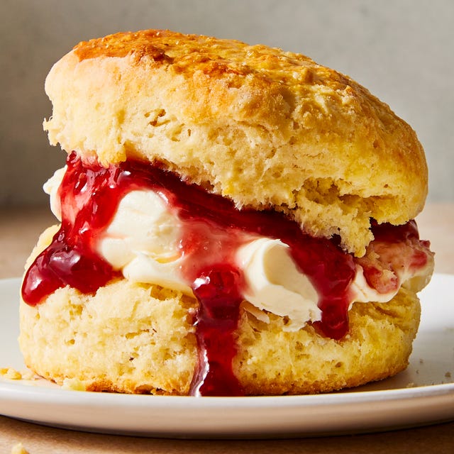 a scone filled with clotted cream and jam on a plate