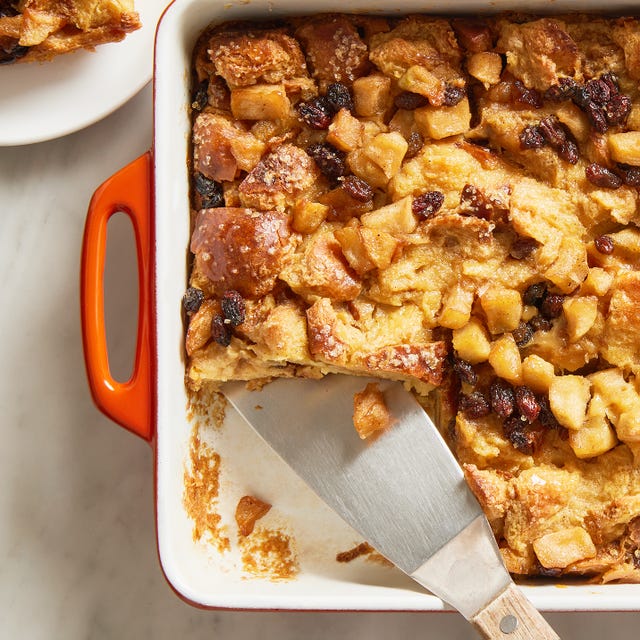 apple bread pudding in a baking dish with a metal spatula