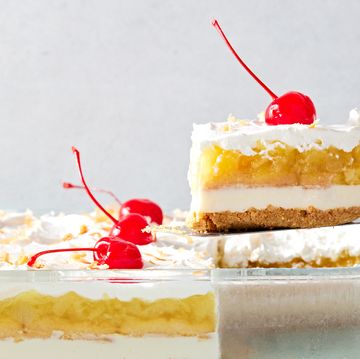 creamy coconut lime cheesecake layered with buttery shortbread cookies, crushed pineapple jello, cool whipped cream, and maraschino cherries all on a graham cracker coconut crust